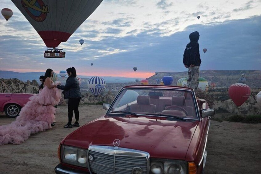 A red convertible car, a pink dress, and hot air balloons in a desert landscape. 3