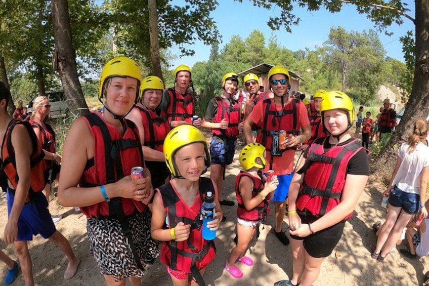 A group of people wearing life jackets and helmets, standing outdoors. 2