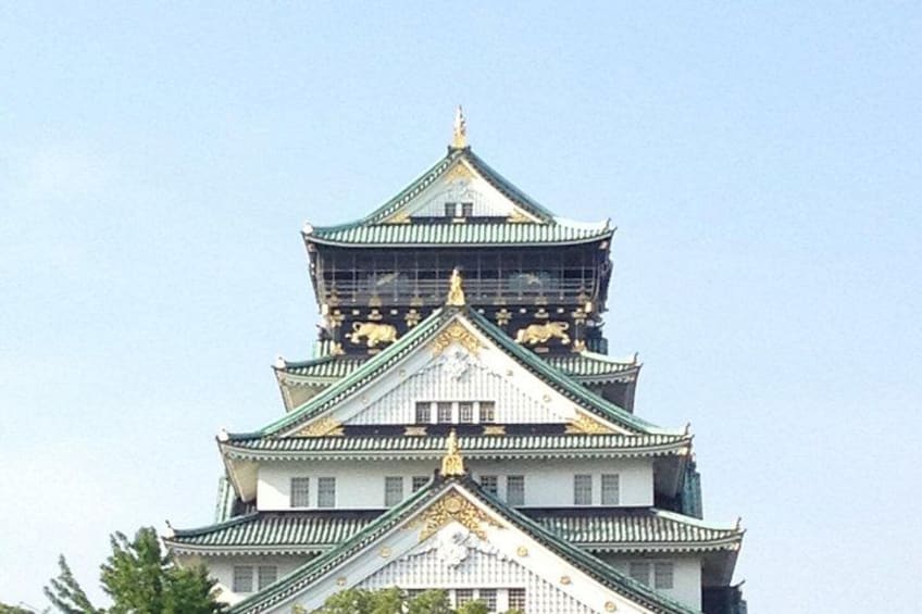 A multi-tiered castle with ornate golden decorations and green roofs. 1