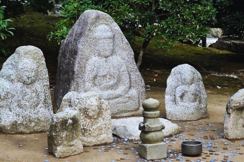 Stone statues in a garden setting. 3