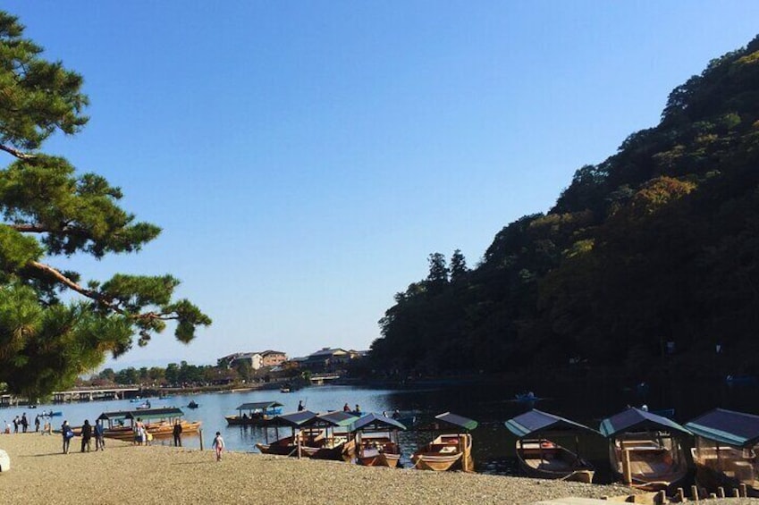 A beach with boats, people, and a forested hill. 5