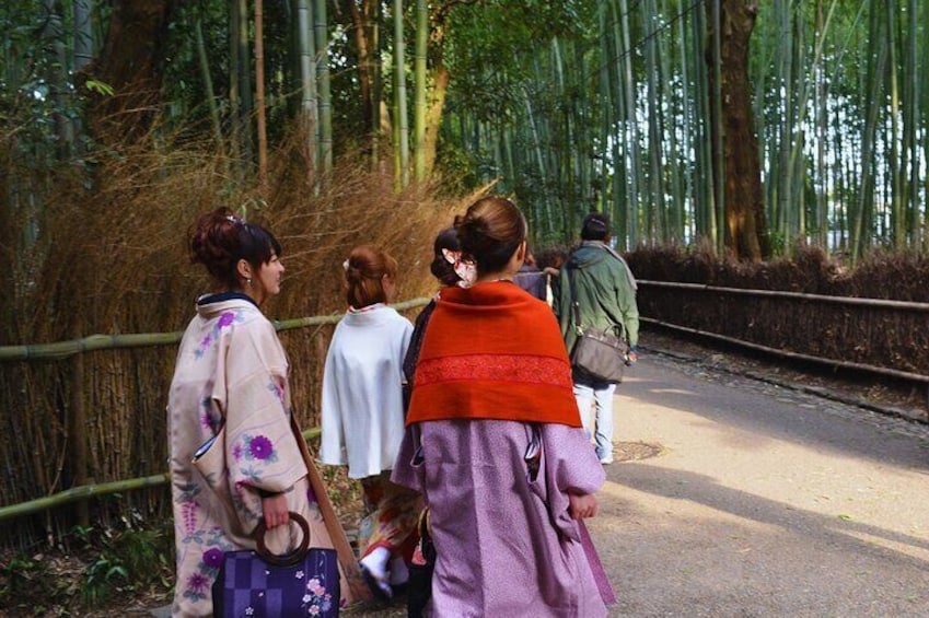 A group of people walking on a bridge surrounded by bamboo trees. 2
