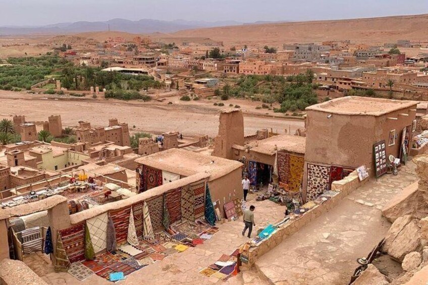 A desert town with traditional architecture, a marketplace, and a view of the surrounding landscape. 4