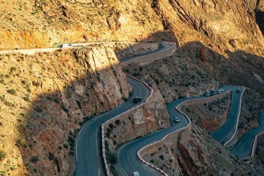 A winding mountain road with vehicles. 2
