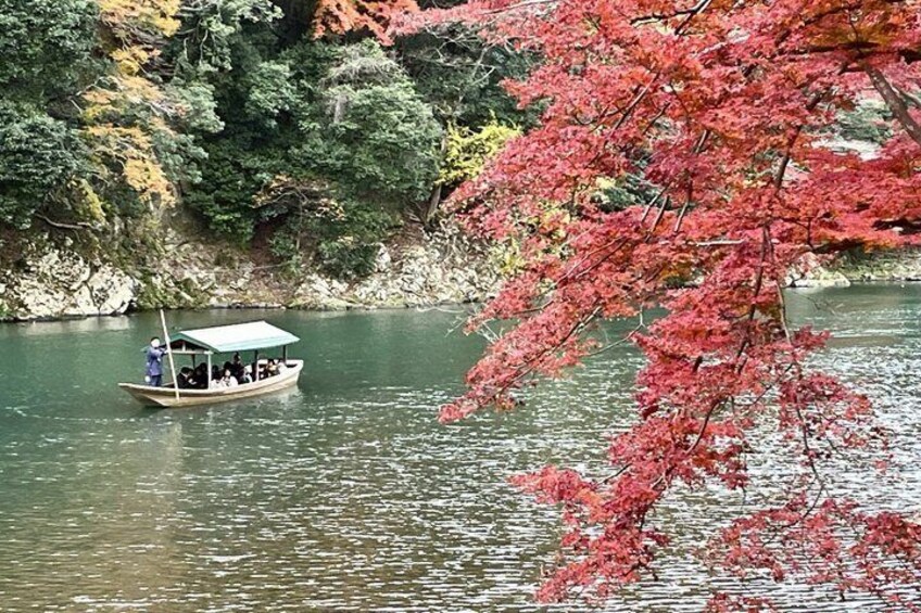 A boat with passengers on a calm river, surrounded by autumn foliage. 5