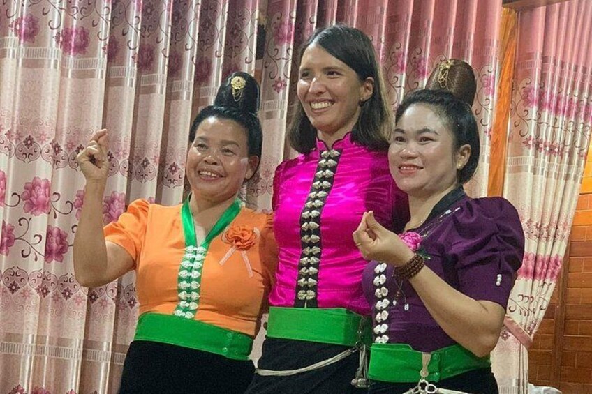 Three individuals wearing traditional attire with green sashes and floral patterns. 3