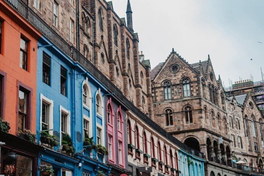 A row of colorful buildings with a historic stone building in the background. 3