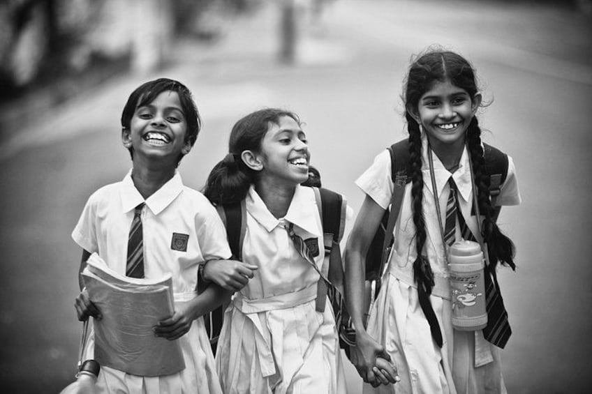 Three children in school uniforms walking together. 1