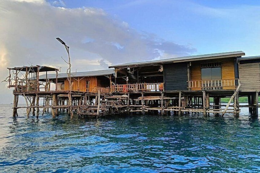 A wooden house on stilts over water. 2