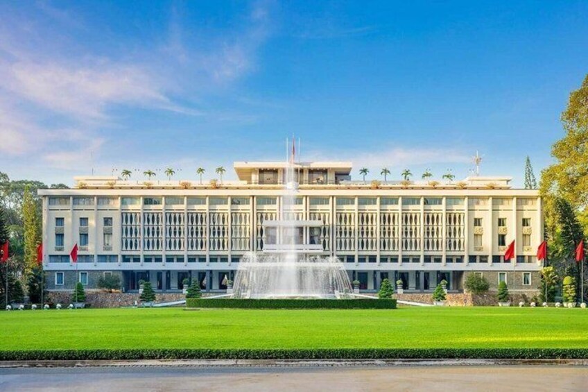 A large building with a central fountain, surrounded by a well-maintained lawn and palm trees. 2