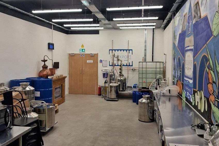 Ett laboratorium med vetenskaplig utrustning, en stor väggmålning och en dörr med texten ”SILKPORT”. 1