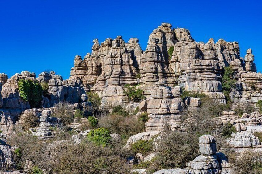 Un paisaje agreste con formaciones rocosas en capas y vegetación escasa. 2