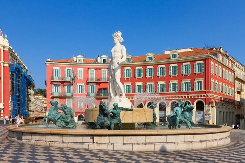 Una fontana con statue in una piazza, circondata da edifici rossi con balconi. 2