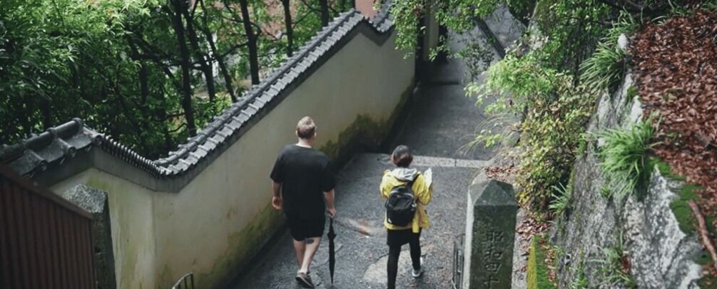 A narrow stone pathway flanked by greenery and traditional architecture. 3