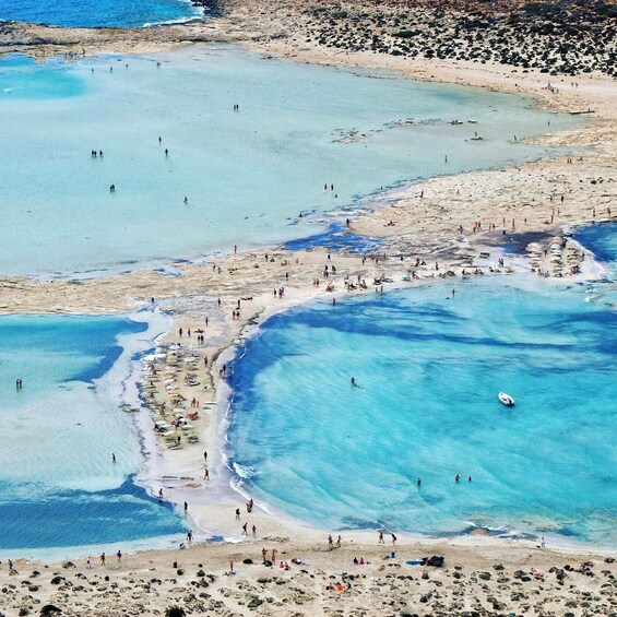 A coastal area with clear blue waters, sandy beaches, and rocky outcrops. 1