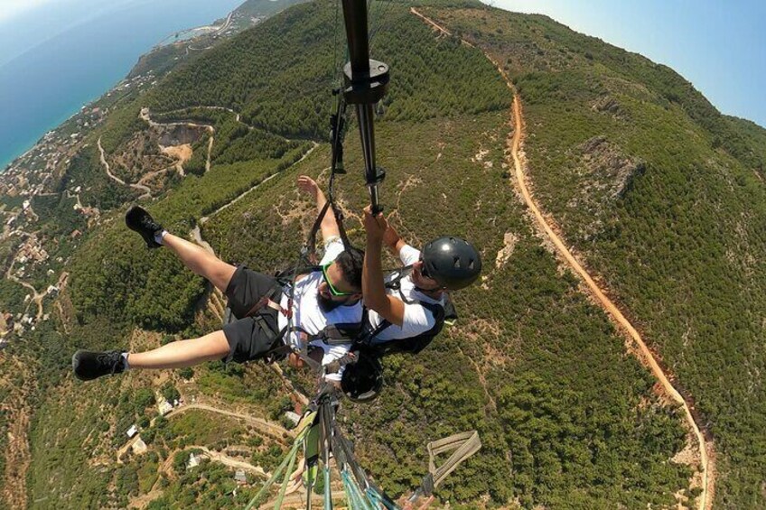 Eine Person mit Fallschirm über einer gebirgigen Landschaft beim Fallschirmspringen. 1