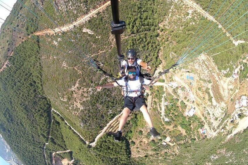 Eine Person mit Fallschirm über einer gebirgigen Landschaft beim Fallschirmspringen. 3