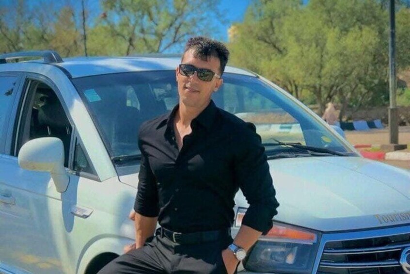 A person sitting on a car with a badge on the front. 2