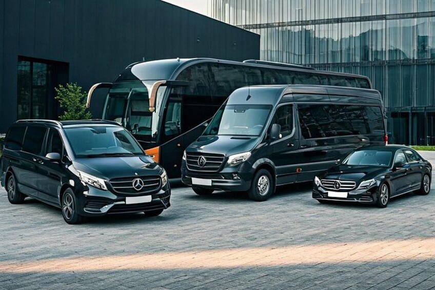 A Mercedes-Benz SUV, a van, and a sedan parked in front of a modern building. 3