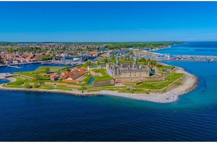 An aerial view of a coastal fortification with a surrounding town and a clear blue sky. 2