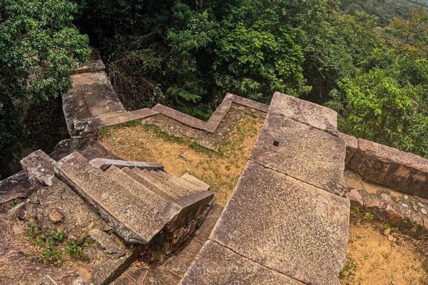 Ancient stone steps leading up a hill, surrounded by dense forest. 4