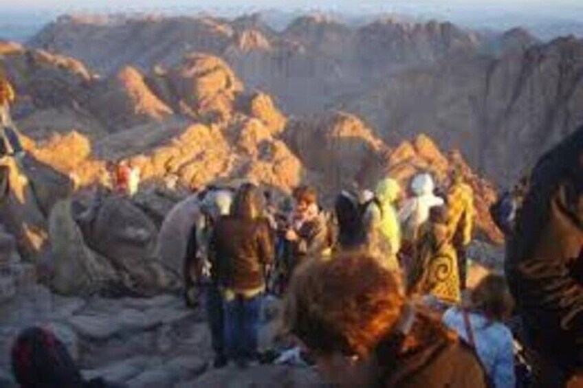 A group of people hiking on a rocky mountain trail. 2