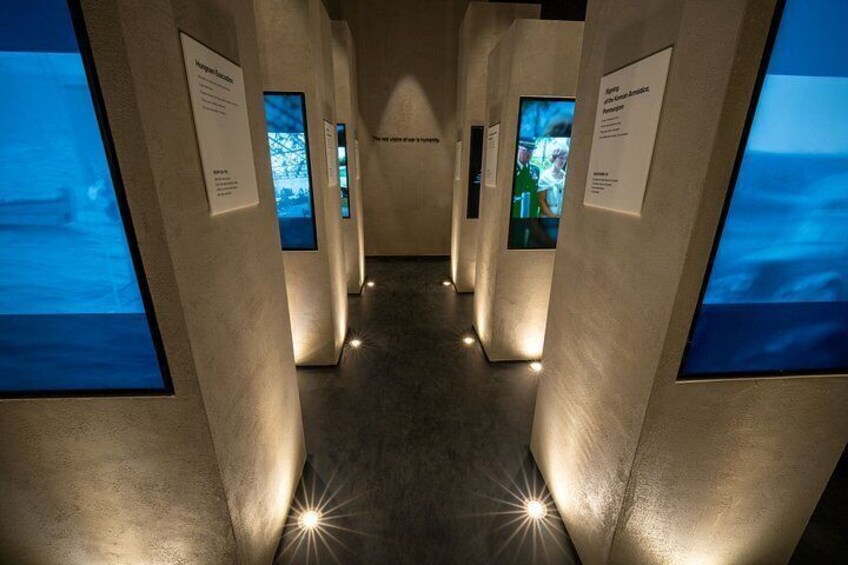 A hallway with illuminated displays and informational plaques. 5