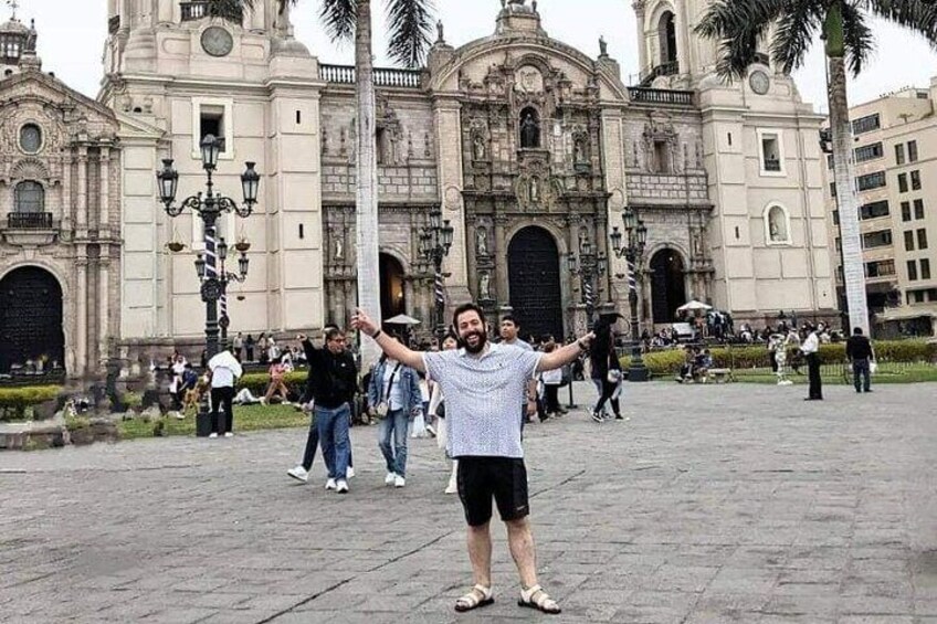 Una persona parada frente a un edificio histórico con arcos y columnas. 1