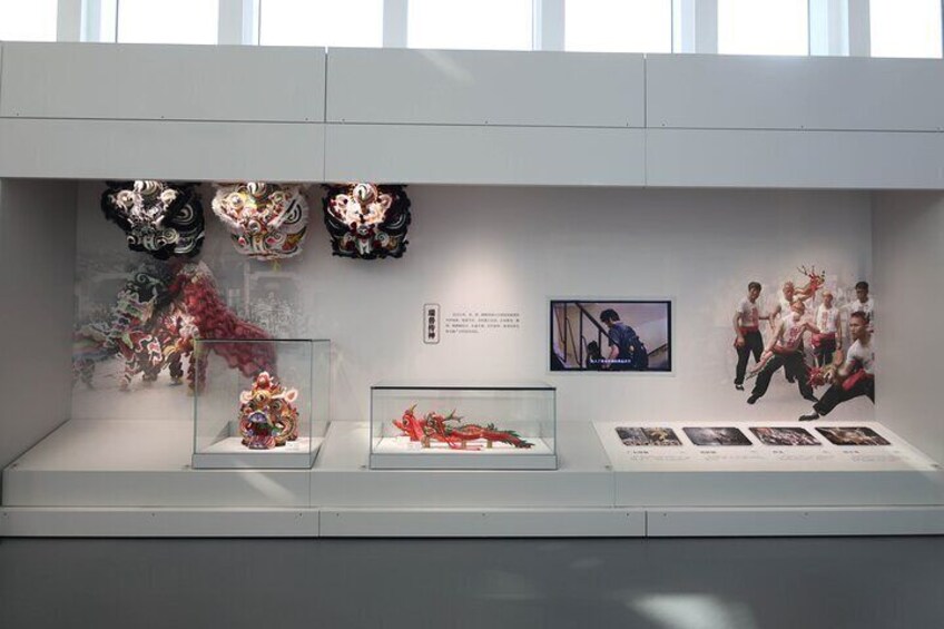 Una mostra museale con maschere tradizionali e fotografie. 5