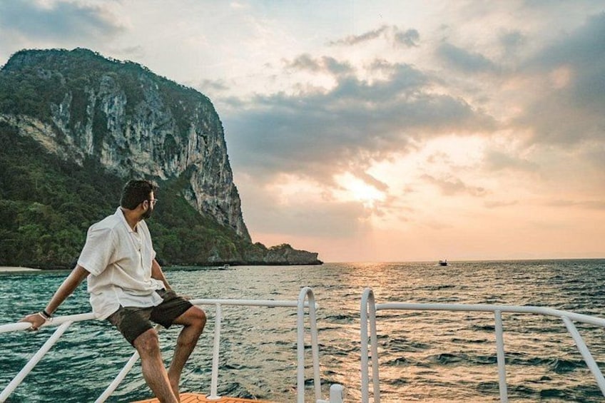 A person sitting on a boat with a mountainous landscape in the background. 1