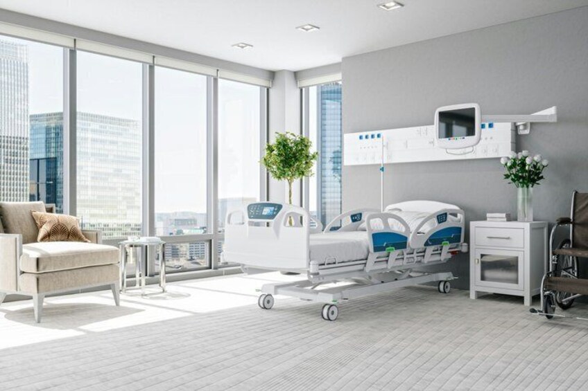A modern hospital room with a hospital bed, a bedside table, a chair, and large windows. 1