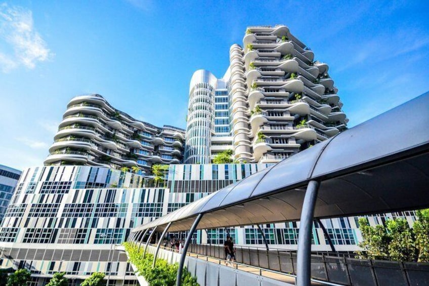 A modern building with curved balconies and a pedestrian walkway. 3