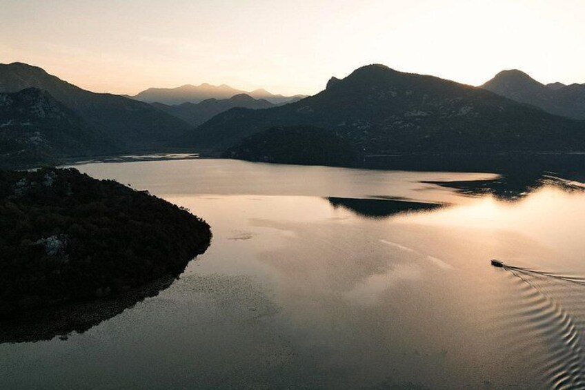 Een rustig meer, omringd door bergen, bij zonsopkomst of zonsondergang. 3