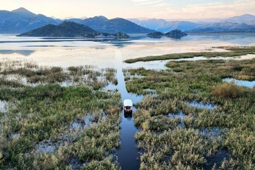 Een rivier kronkelt door een moerassig landschap met bergen op de achtergrond. 5