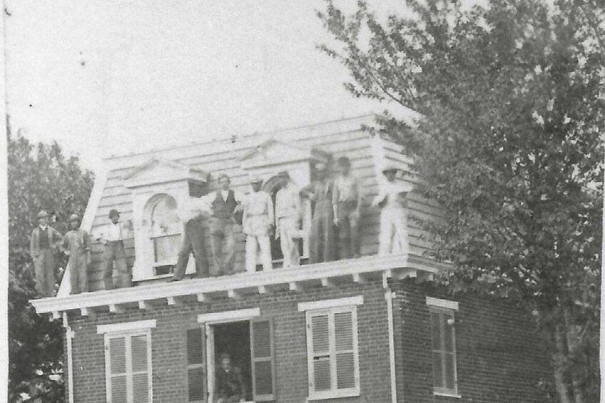 Ein zweistöckiges Backsteinhaus mit einem Balkon. 2