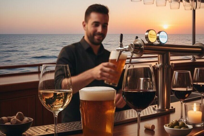 En person skænker øl i et glas på en bar med solnedgang i baggrunden. 2