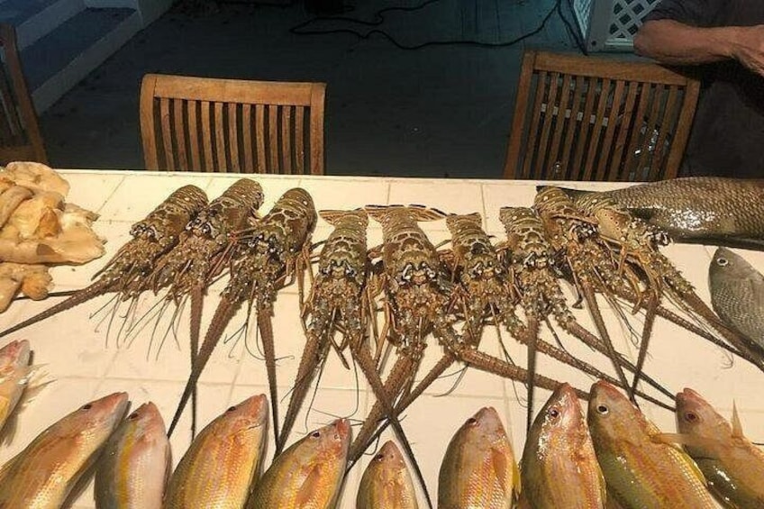 A table with various seafood, including lobsters and fish. 3