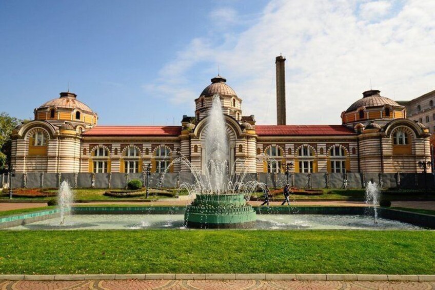 Un edificio histórico con arquitectura abovedada y una fuente central. 5