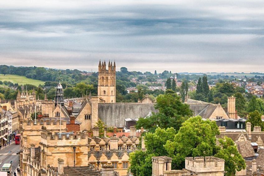 A historic cityscape with prominent medieval architecture, including a tower and a large fortress-like structure. 2
