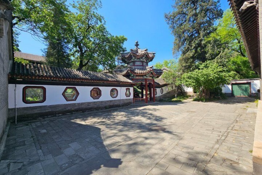 A traditional Chinese courtyard with a pagoda, tiled roof, and a stone pathway. 5