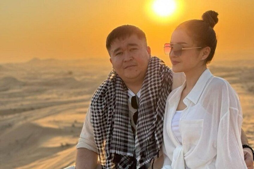 A couple standing with a sunset in the background. 5