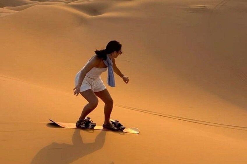 Una persona che fa snowboard su una duna di sabbia. 3