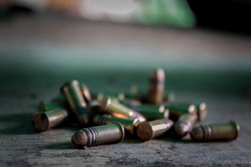A pile of spent bullets on a wooden surface. 4