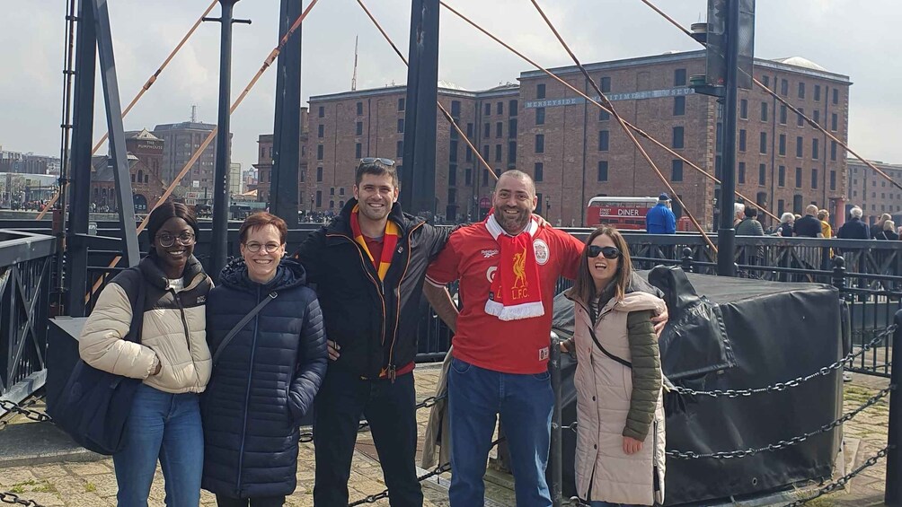 A group of people standing on a bridge with a cityscape in the background. 4