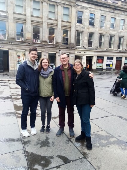 A group of people standing in a public square with a historic building in the background. 3
