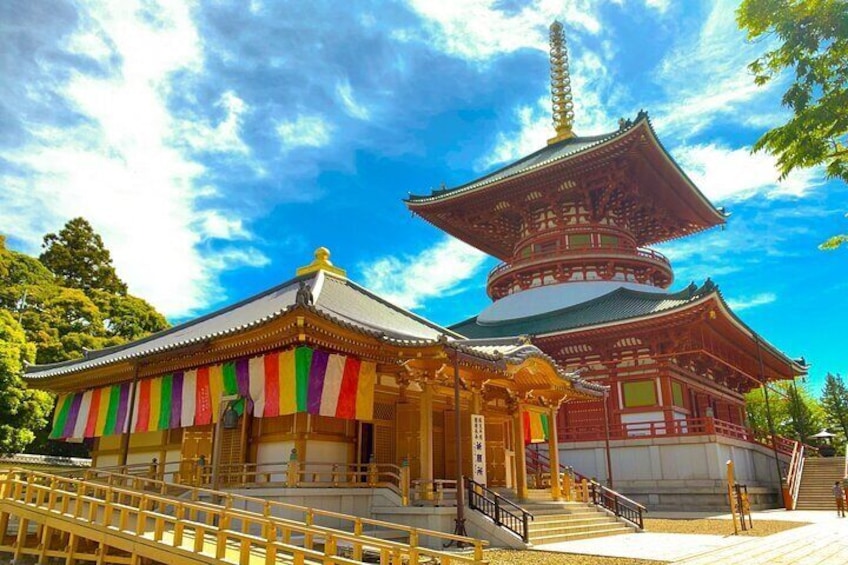 A traditional Japanese temple with a large pagoda and colorful flags. 1