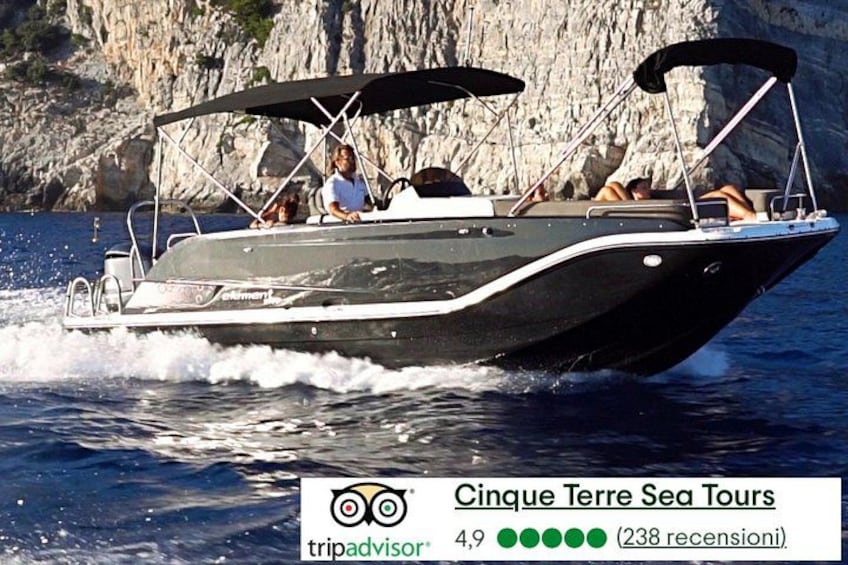A boat with a canopy, people on board, and a rocky coastline in the background. 1