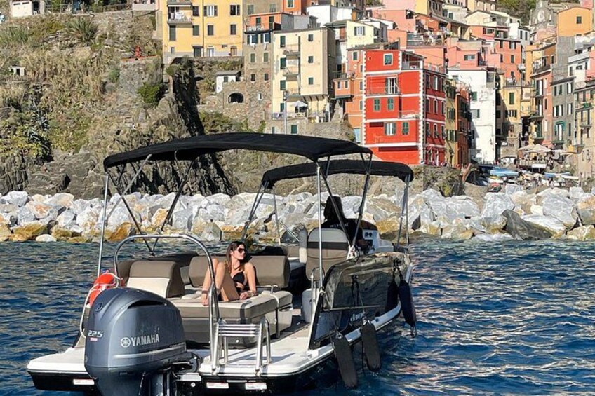 A motorboat with a Yamaha outboard motor, a person in a swimsuit, and colorful buildings in the background. 2