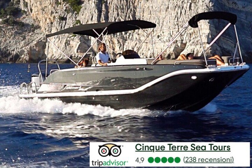 A motorboat on water with a rocky coastline in the background. 1