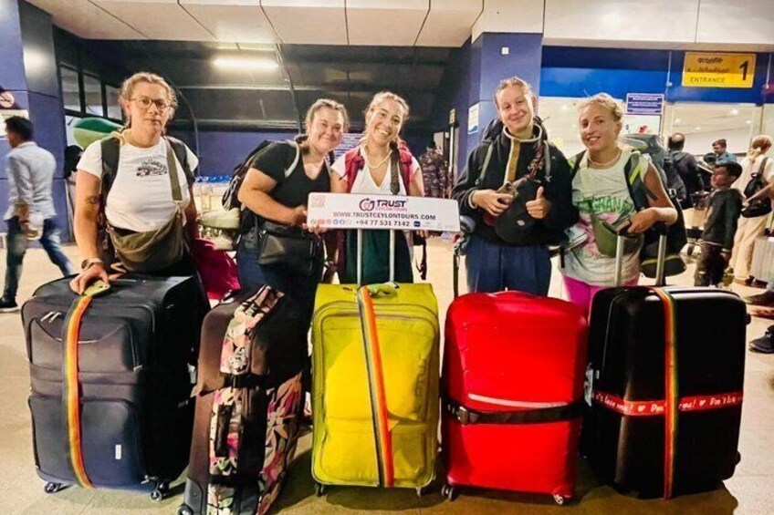 Four people with luggage at an airport. 2